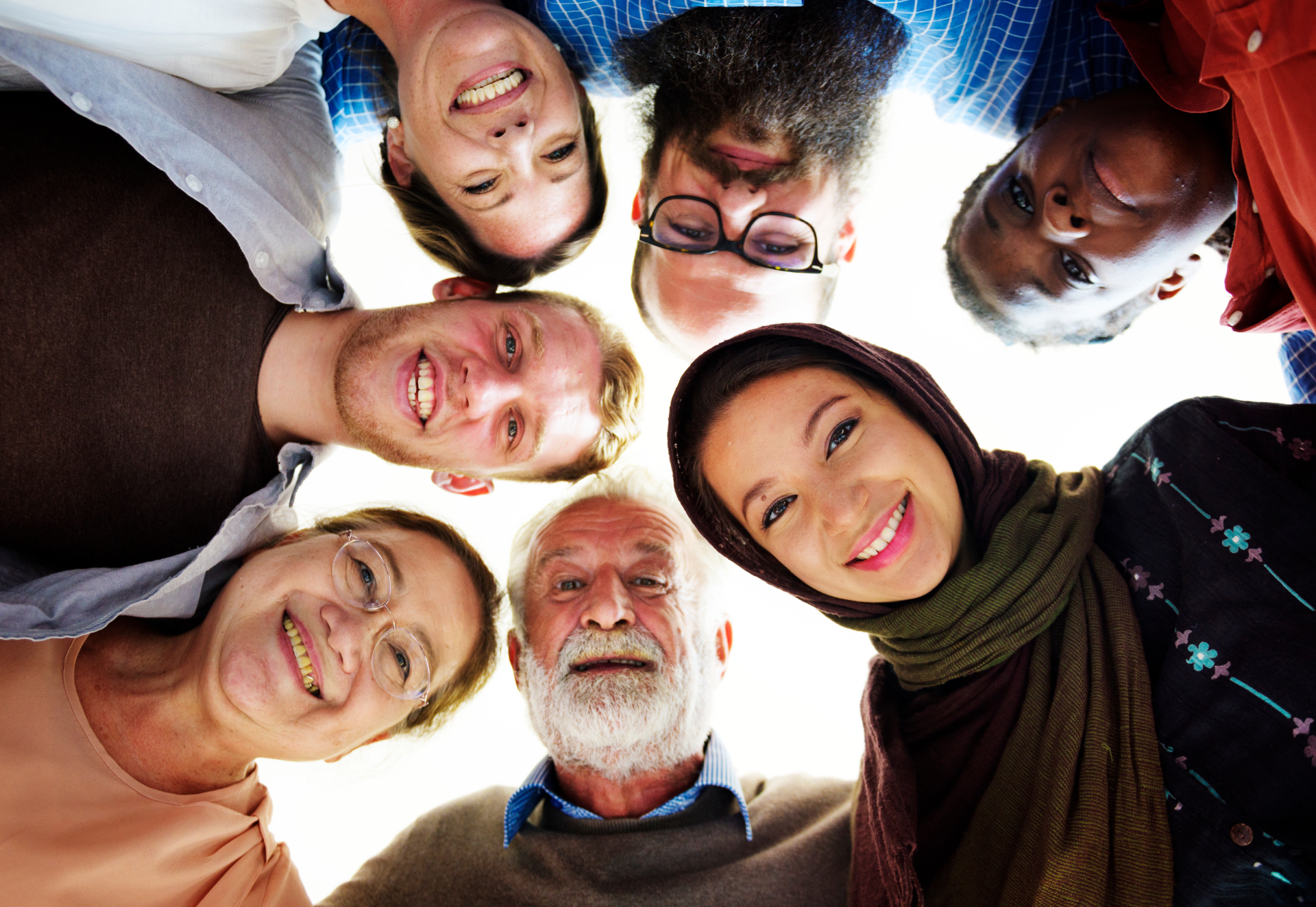 A diverse community group standing together in warm golden light.
